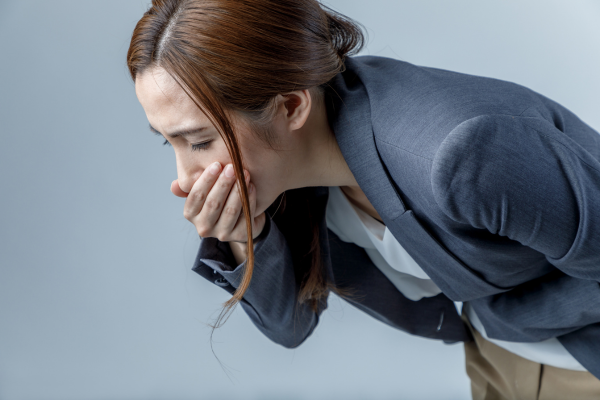 腹痛嘔吐を感じている女性