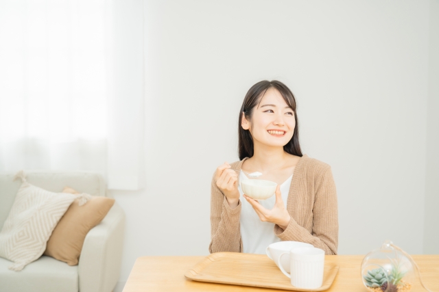 ヨーグルトを食べている女性