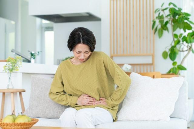 おなかを痛がる女性